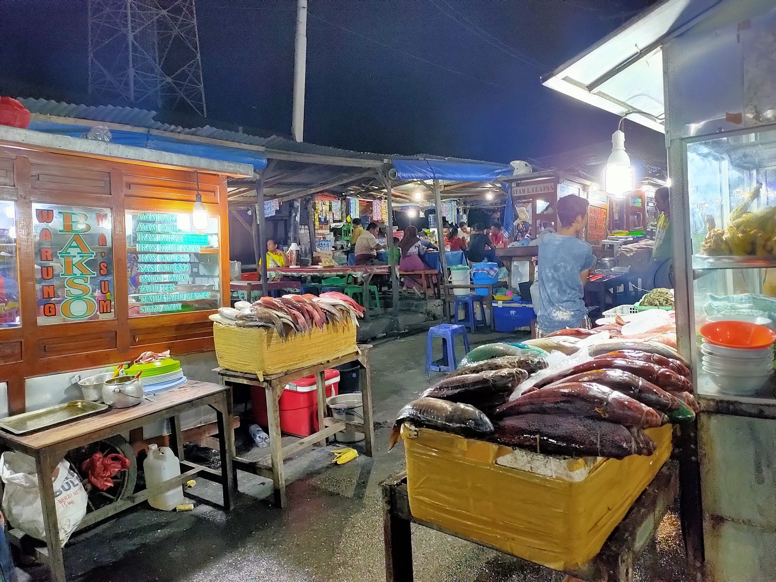 Nikmati kuliner malam di Pasar Malam Seafood Kampung Solor Kupang. Aneka ikan bakar, kuah asam, hingga kangkung bunga pepaya siap memanjakan lidah.